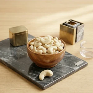 নন-রোস্টেড পাহাড়ি কাজু বাদাম কাঠের বাটিতে ডার্ক মার্বেল বোর্ডে rangaghorbd